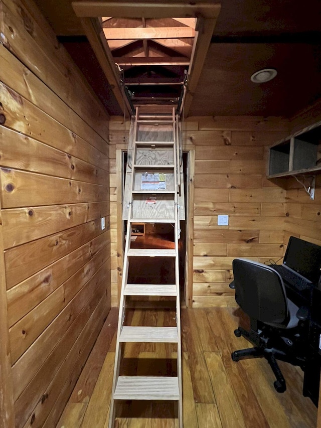 staircase featuring hardwood / wood-style floors and wooden walls