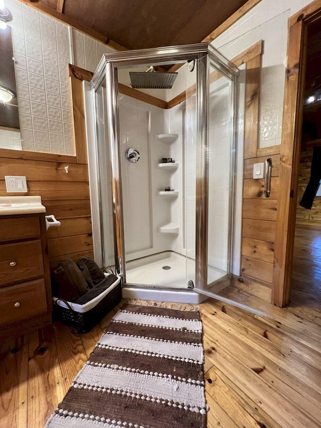 bathroom featuring a shower with door, hardwood / wood-style flooring, and vanity