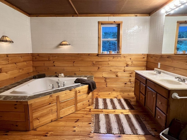 bathroom with vanity, wood walls, a bathing tub, and wood-type flooring