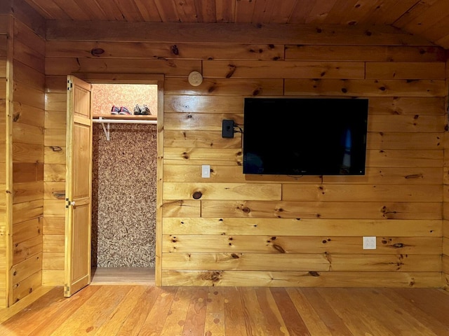 unfurnished living room featuring wooden ceiling, lofted ceiling, hardwood / wood-style floors, and wood walls