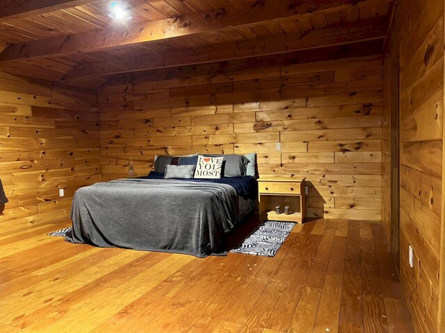 bedroom featuring wooden ceiling, hardwood / wood-style flooring, beam ceiling, and wooden walls