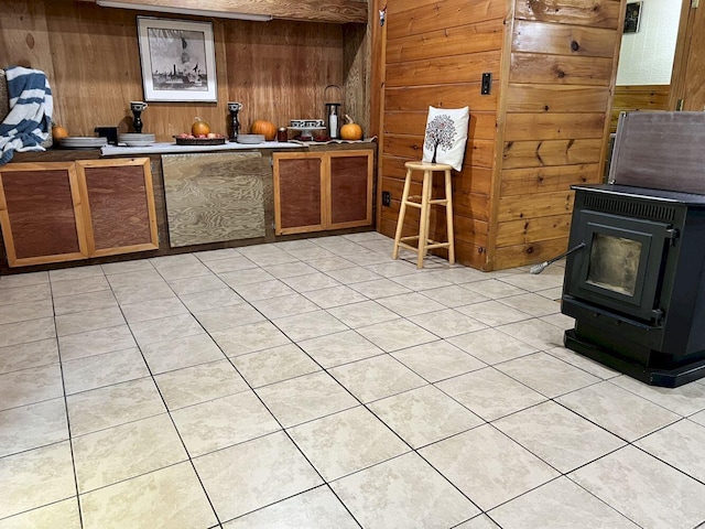 kitchen featuring wood walls, light tile patterned floors, and a wood stove