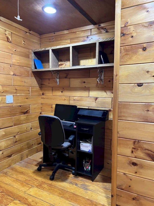 office area with hardwood / wood-style floors and wooden walls