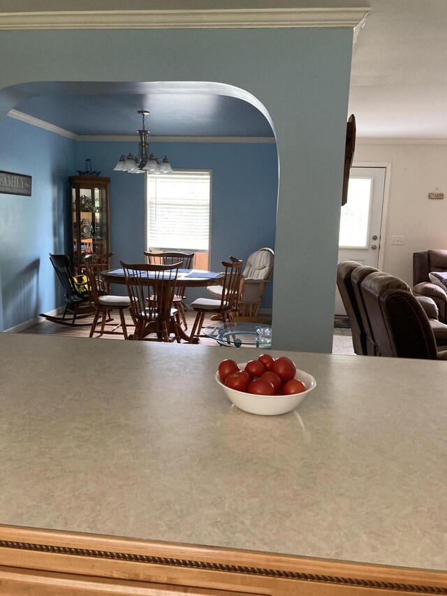 dining space featuring an inviting chandelier, ornamental molding, and plenty of natural light