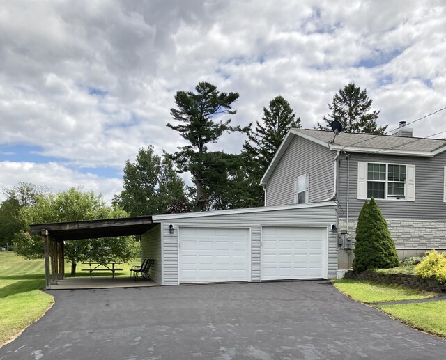 view of side of property featuring a garage and a yard