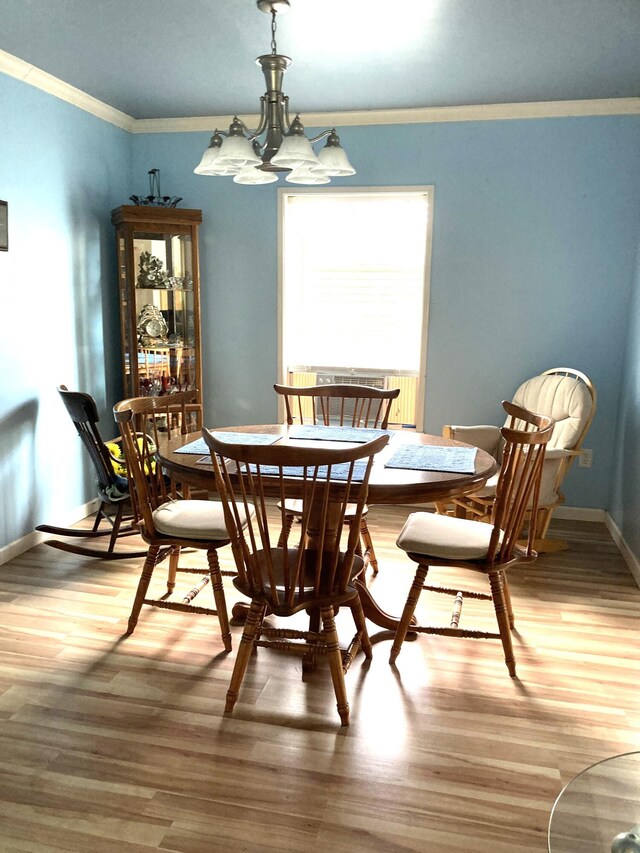 dining area with crown molding and hardwood / wood-style floors