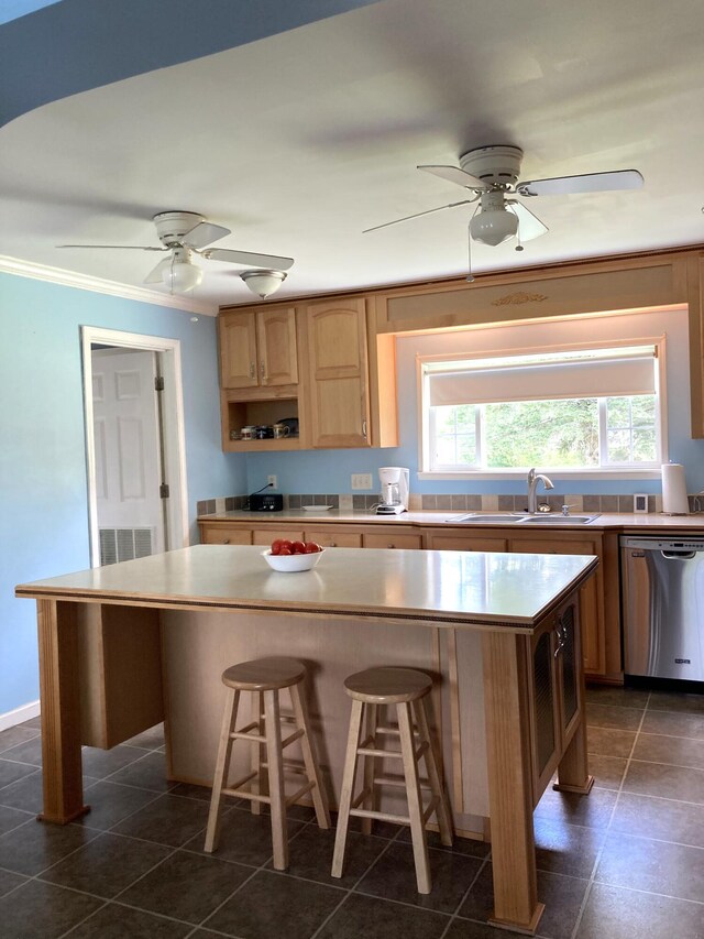 kitchen with sink, a center island, stainless steel dishwasher, and a kitchen breakfast bar