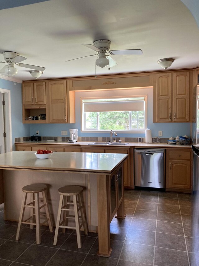 kitchen featuring sink, ceiling fan, a kitchen breakfast bar, a center island, and stainless steel dishwasher