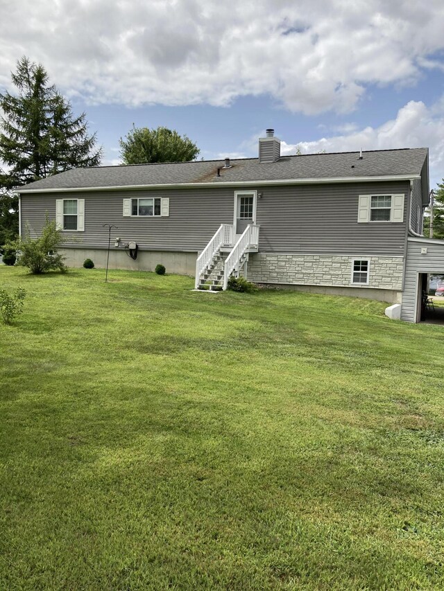 rear view of property featuring a yard