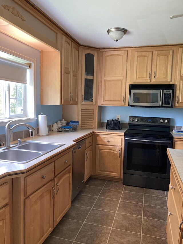 kitchen featuring light brown cabinetry, sink, dark tile patterned floors, and appliances with stainless steel finishes