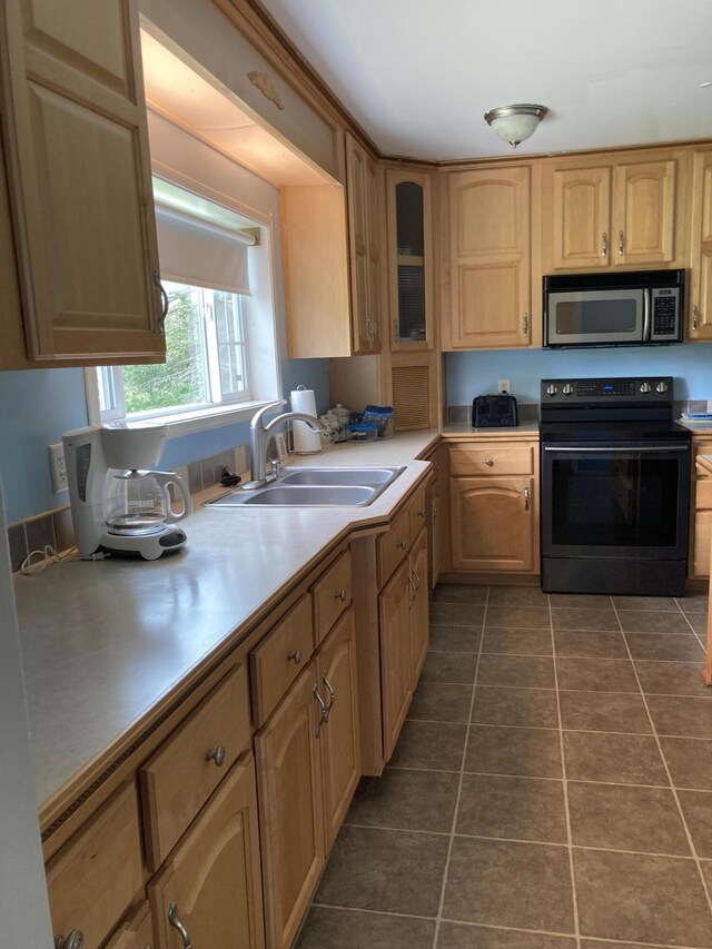 kitchen with black electric range oven, sink, and dark tile patterned flooring