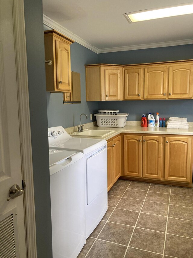 washroom featuring sink, crown molding, cabinets, dark tile patterned floors, and washer and clothes dryer