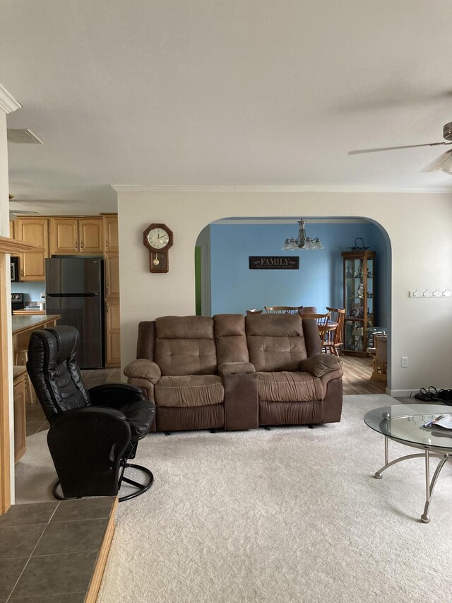 carpeted living room featuring crown molding and ceiling fan