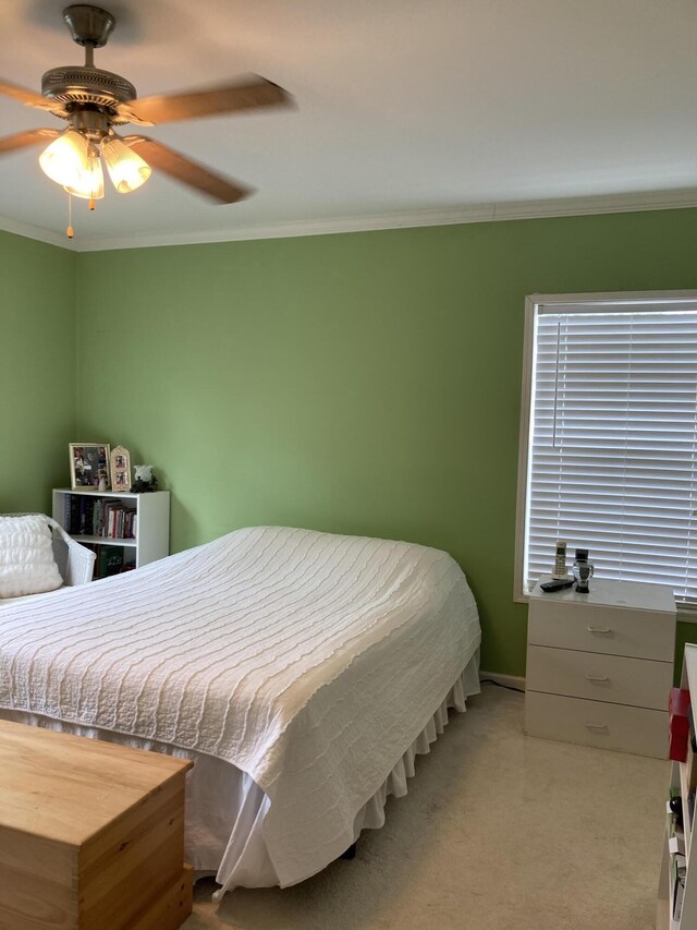 bedroom featuring crown molding, ceiling fan, and light colored carpet