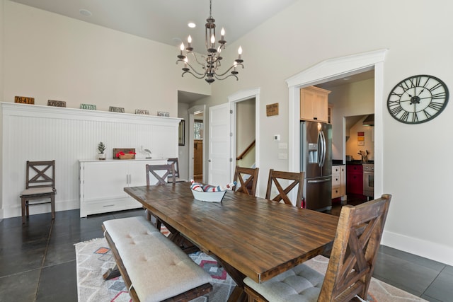 dining space with a chandelier, high vaulted ceiling, and sink