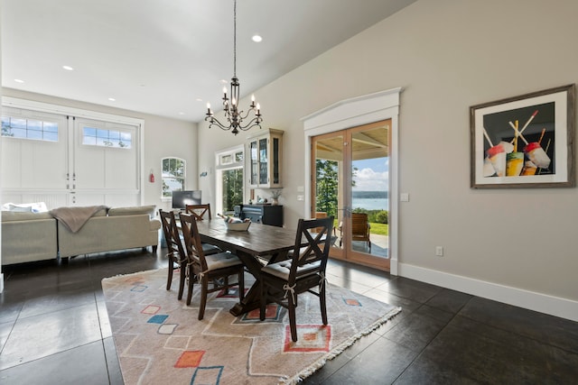 dining room featuring french doors, vaulted ceiling, and a notable chandelier