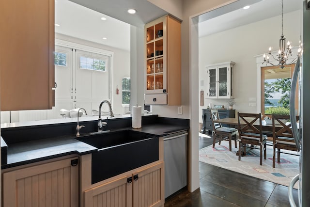 kitchen featuring pendant lighting, sink, stainless steel appliances, and an inviting chandelier