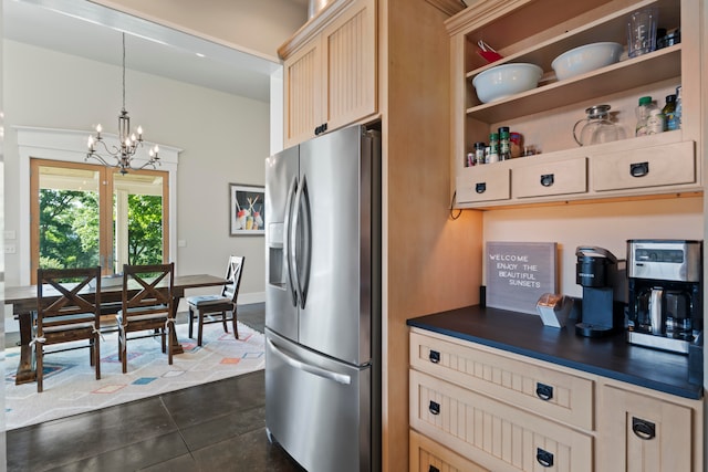 kitchen with hanging light fixtures, an inviting chandelier, stainless steel fridge with ice dispenser, light brown cabinetry, and dark tile patterned flooring