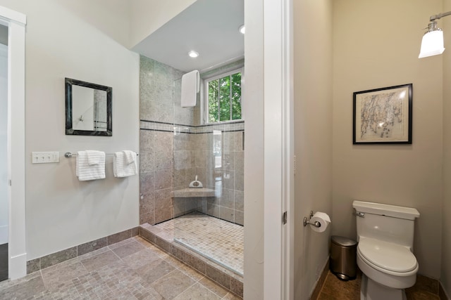 bathroom featuring tiled shower and toilet