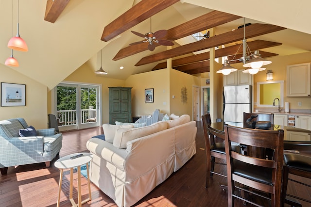 living room with wood-type flooring, vaulted ceiling with beams, ceiling fan, and sink