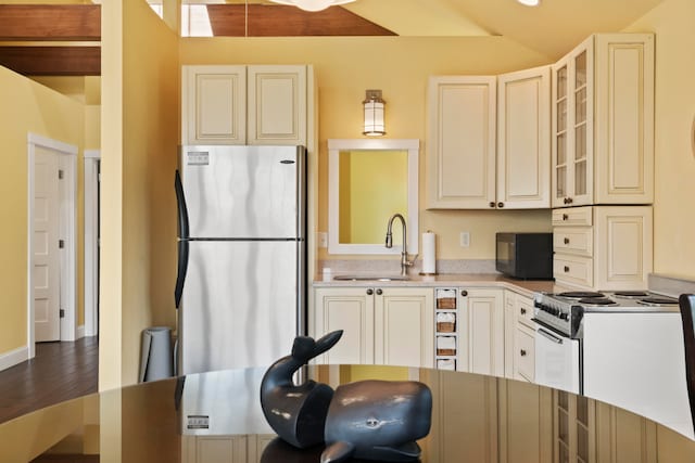 kitchen featuring hardwood / wood-style flooring, sink, stainless steel refrigerator, and white stove