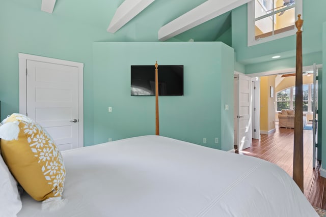 bedroom featuring beam ceiling, hardwood / wood-style flooring, high vaulted ceiling, and a closet