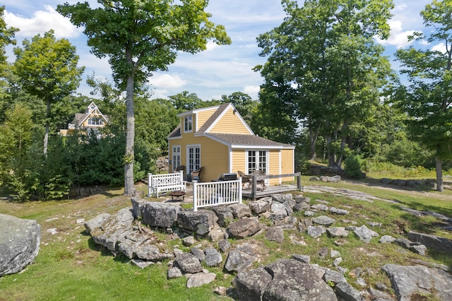 back of property featuring a lawn and a wooden deck