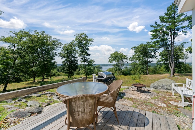 wooden deck with grilling area and a fire pit