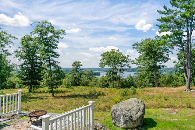 view of yard with a water view and an outdoor fire pit