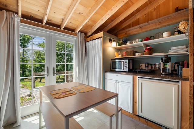 kitchen featuring white cabinets, vaulted ceiling with beams, light tile patterned floors, and wooden ceiling