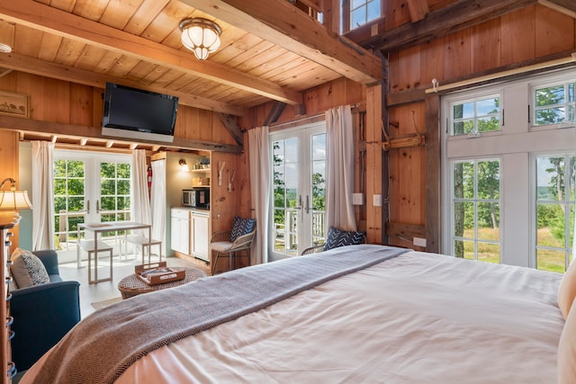 bedroom featuring beamed ceiling, french doors, wood ceiling, and wood walls