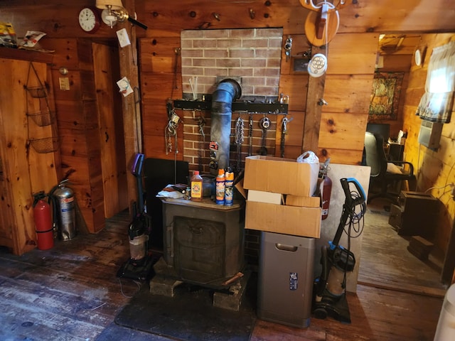 interior space with hardwood / wood-style flooring, a wood stove, and wooden walls