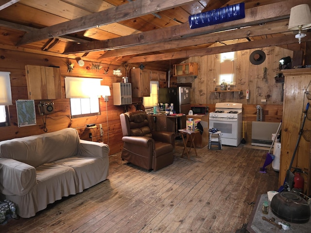 living area with dark wood-style floors, beam ceiling, and wood walls