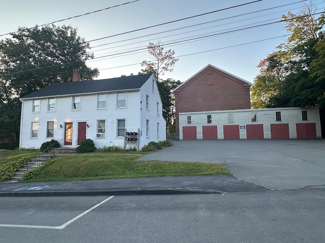 colonial-style house with a chimney and a front yard