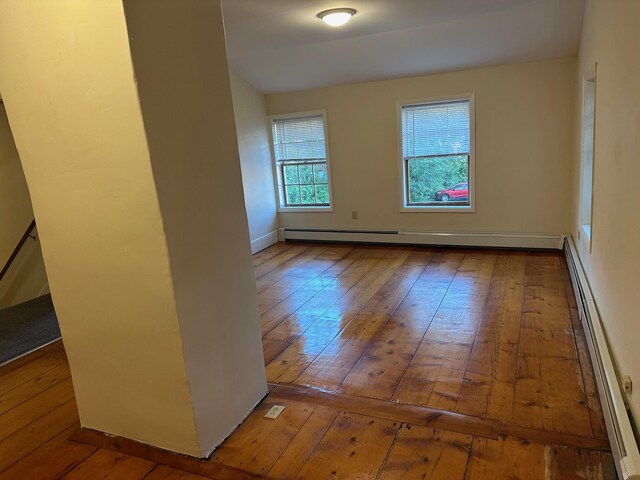 unfurnished room featuring a baseboard radiator and hardwood / wood-style flooring