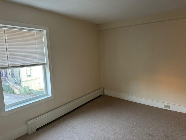 empty room featuring a baseboard radiator and carpet