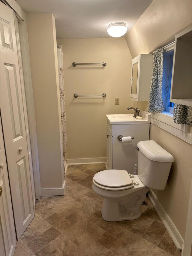 bathroom with curtained shower, toilet, and vanity