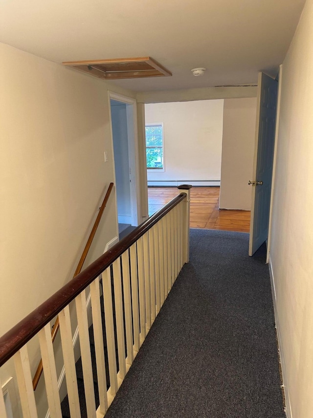 hall featuring carpet flooring and an upstairs landing