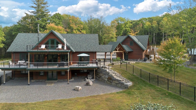 back of house featuring a deck, a fenced backyard, a patio area, and a lawn