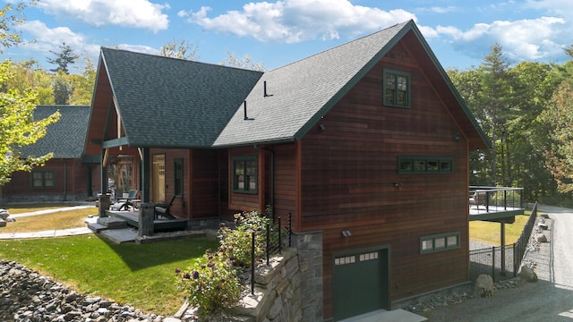 view of front of home featuring a garage, a front lawn, and roof with shingles