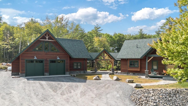view of front of home with dirt driveway and an attached garage