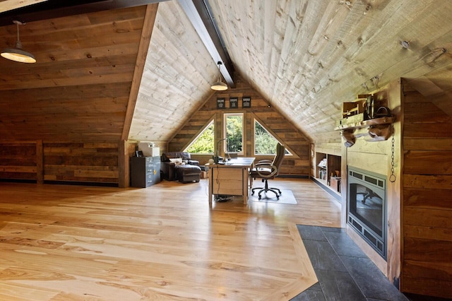 home office featuring wood walls, lofted ceiling with beams, hardwood / wood-style floors, and a fireplace with flush hearth