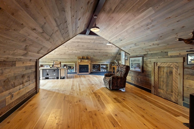 additional living space featuring lofted ceiling with beams, wooden ceiling, wood walls, and hardwood / wood-style floors