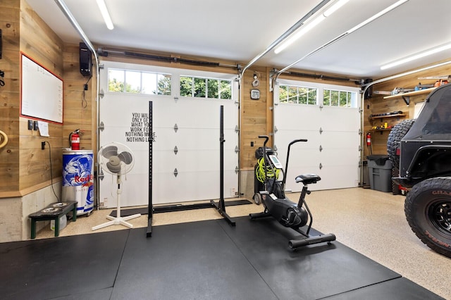 workout room featuring a garage and wood walls