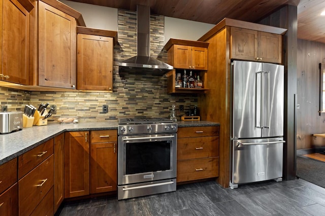 kitchen featuring wooden ceiling, brown cabinetry, tasteful backsplash, wall chimney exhaust hood, and appliances with stainless steel finishes