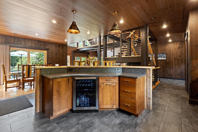 bar with wood ceiling, wooden walls, hanging light fixtures, and wine cooler