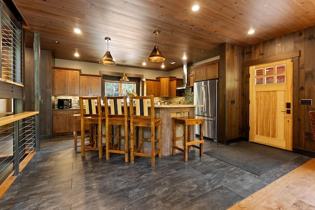 kitchen with wall chimney exhaust hood, wooden ceiling, high end fridge, and decorative backsplash