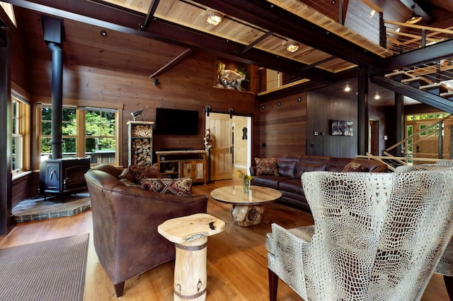 living room featuring wood finished floors, wood ceiling, beamed ceiling, wood walls, and a wood stove