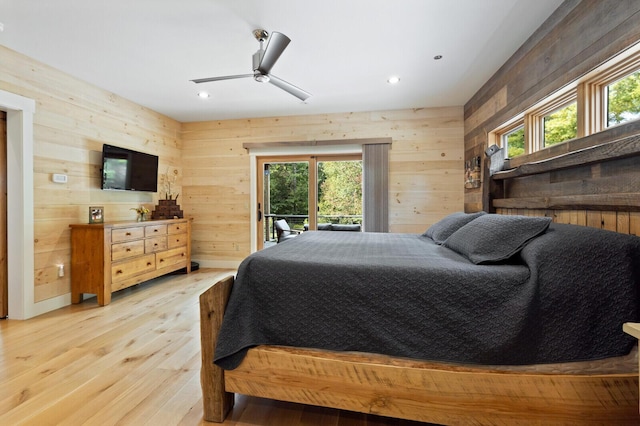 bedroom with recessed lighting, access to outside, wooden walls, and light wood finished floors