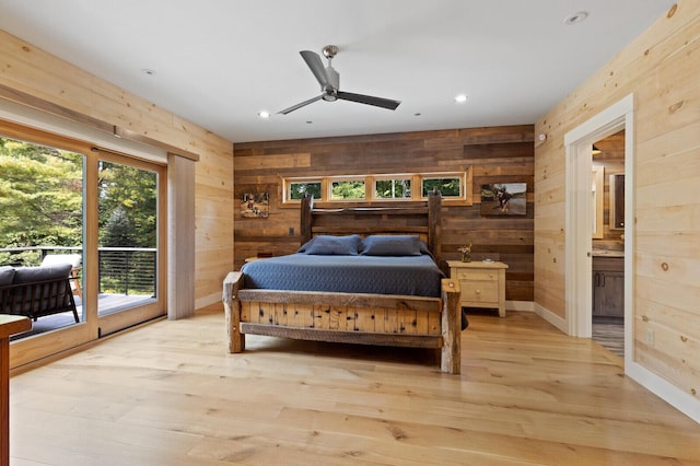 bedroom with light wood-style flooring, baseboards, wooden walls, recessed lighting, and access to outside